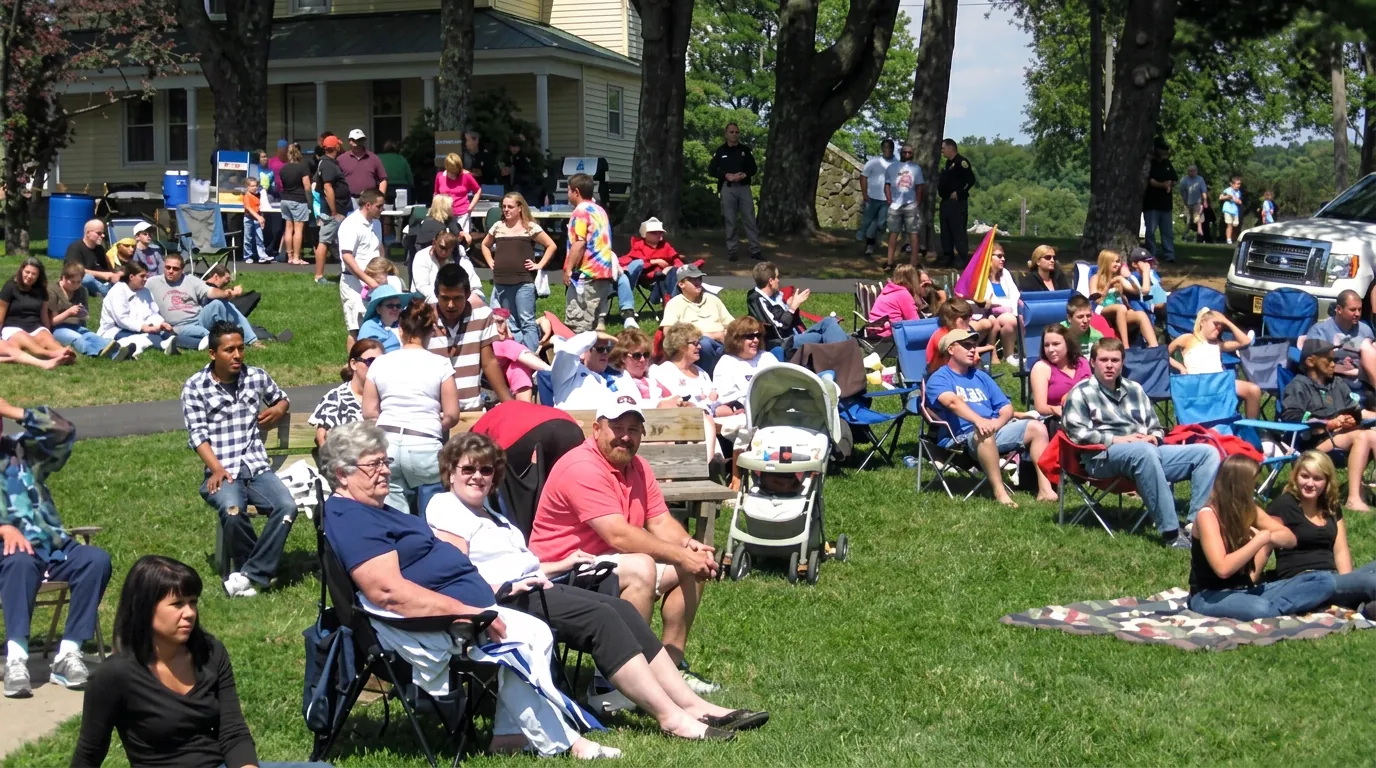 A large crowd in lawn chairs watching a concert in Crouse Park