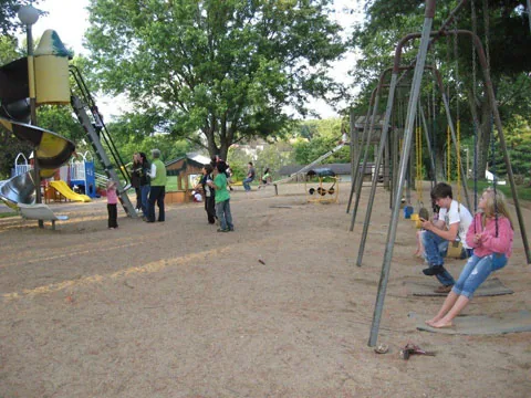 Children and families at the playground swings and slide