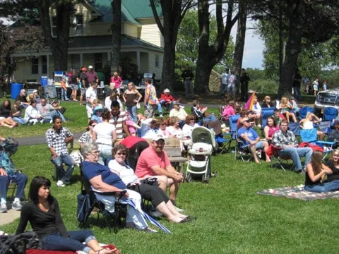 A large crowd in lawn chairs at a concert in Crouse Park